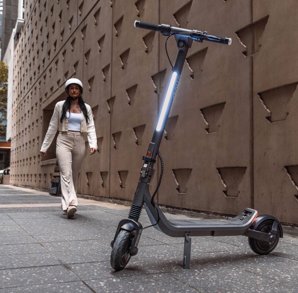 Apollo Go electric commuter scooter parked on a city sidewalk
