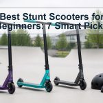 Three beginner stunt scooters beside protective gear at a skatepark