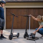 Parent measuring handlebar height and deck fit for a taller older child choosing an electric scooter